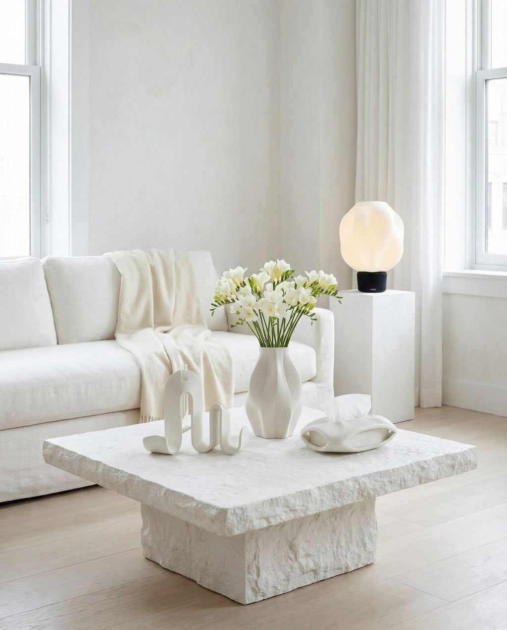 AMINI STRIA Complete Set in White — all four pieces in a bright minimalist living room with white freesias on a stone coffee table, lamp on white pedestal