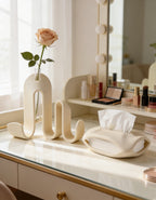 AMINI STRIA Entry Set in Cream — book holder with single peach rose in glass tube and tissue holder on a cream makeup vanity with Hollywood mirror