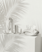 AMINI STRIA Entry Set in White — book holder and tissue holder on a white cube with palm shadows
