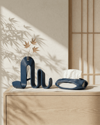 AMINI STRIA Entry Set in Navy — book holder with dried maple leaves in glass tube and tissue holder on a light oak sideboard with shoji screen and bamboo shadows