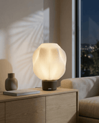 AMINI STRIA Lamp in Charcoal — lit at night on a sideboard, city lights through window with palm shadow