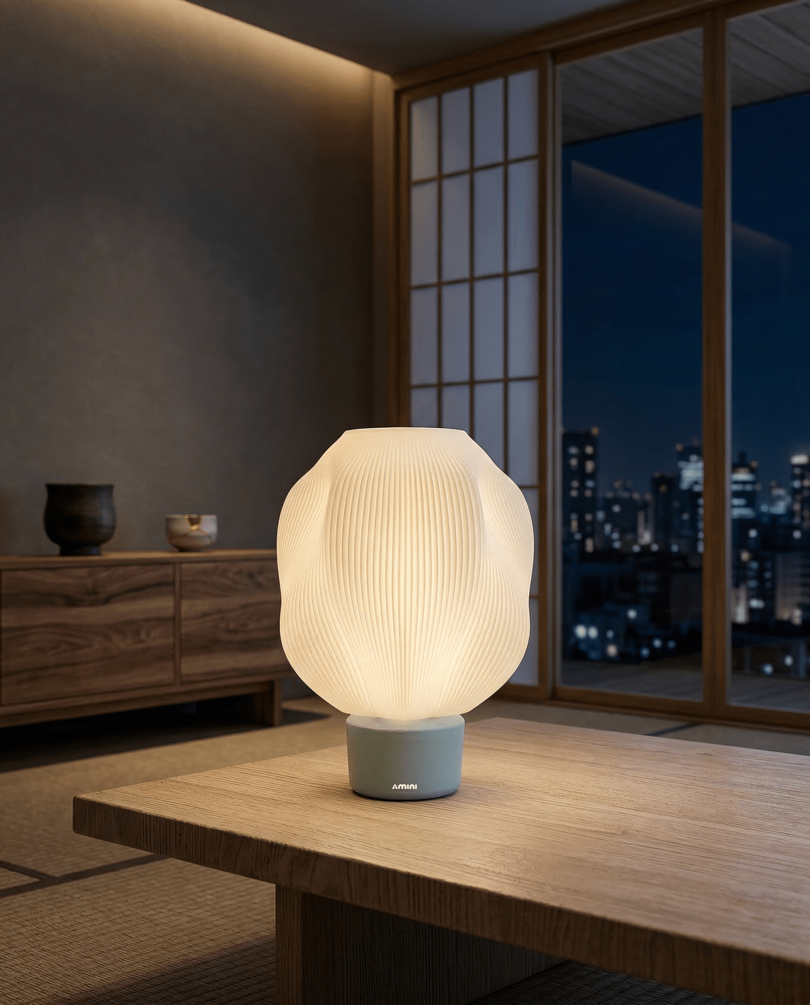 AMINI STRIA Lamp in Baby Blue — lit at night on a low wooden table in a Japanese tatami room with city skyline