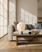 AMINI STRIA Lamp in Baby Blue — on a walnut coffee table in a living room with blue cushion sofa