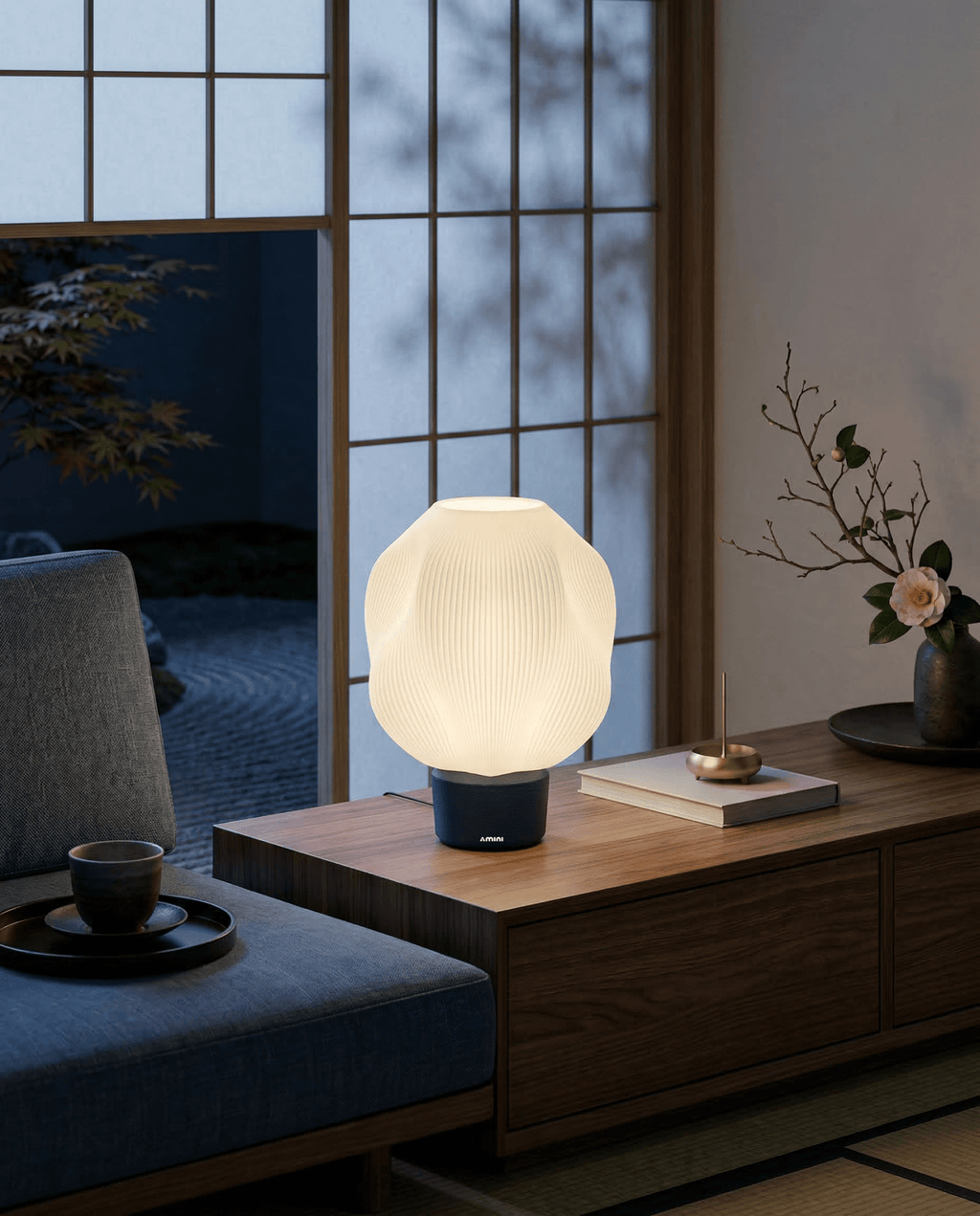 AMINI STRIA Lamp in Navy — lit at night on a wooden sideboard in a traditional Japanese room with garden view through shoji screens