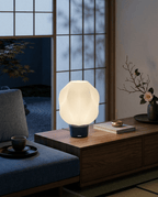 AMINI STRIA Lamp in Navy — lit at night on a wooden sideboard in a traditional Japanese room with garden view through shoji screens