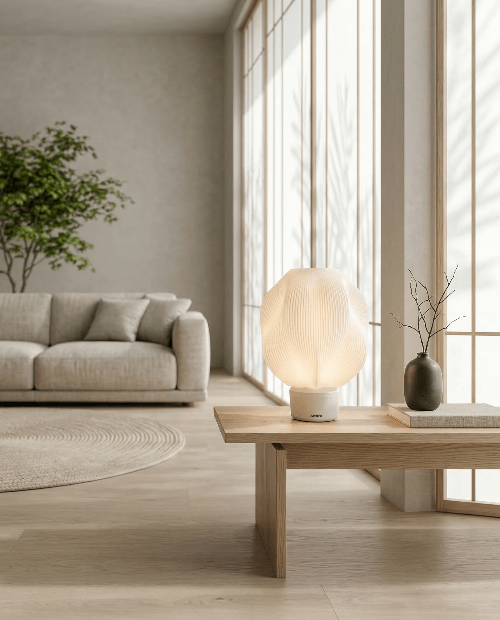AMINI STRIA Lamp in White — on a low coffee table in a bright Scandinavian-style living room with dark vase and branches