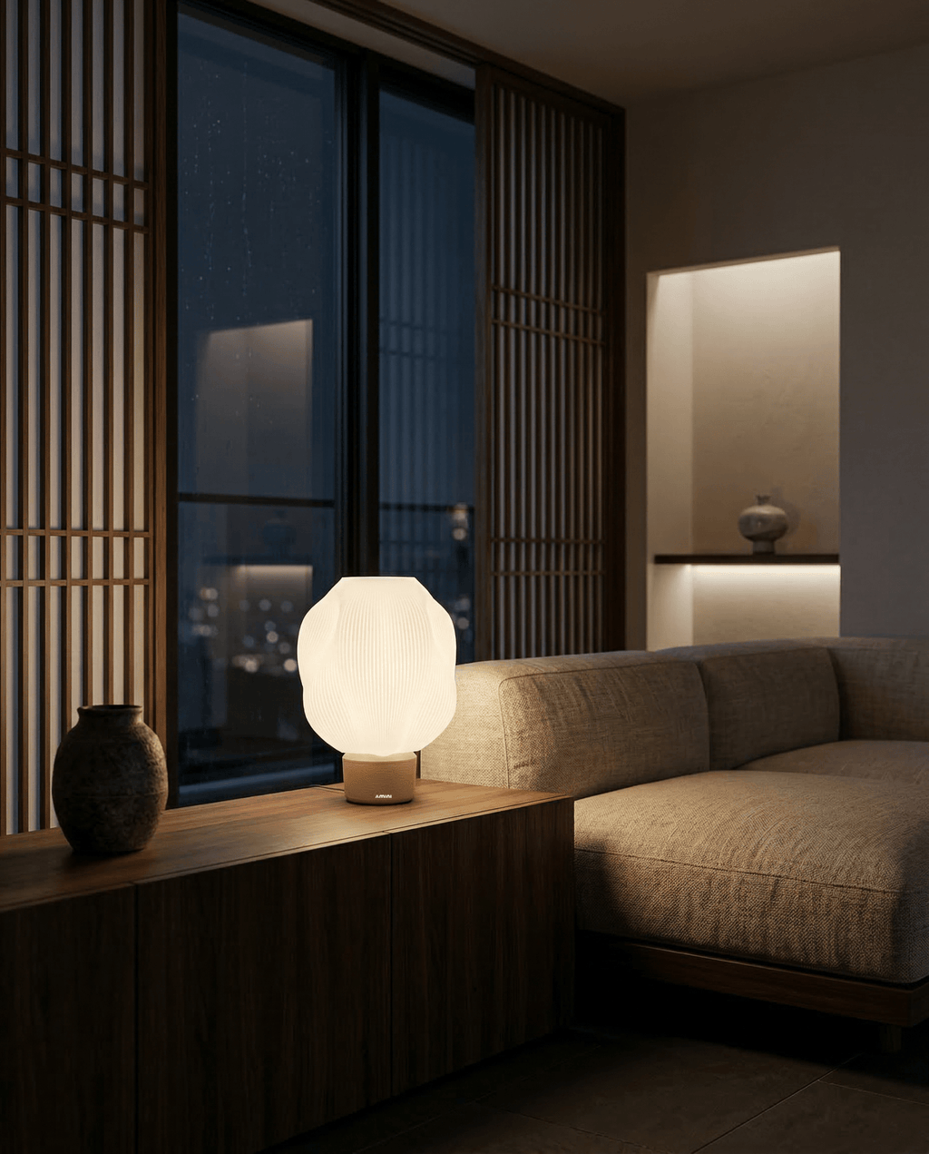 AMINI STRIA Lamp in Cream — lit at night on a low Japanese-style sideboard with dark vase and wood slat room divider