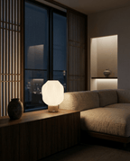 AMINI STRIA Lamp in Cream — lit at night on a low Japanese-style sideboard with dark vase and wood slat room divider