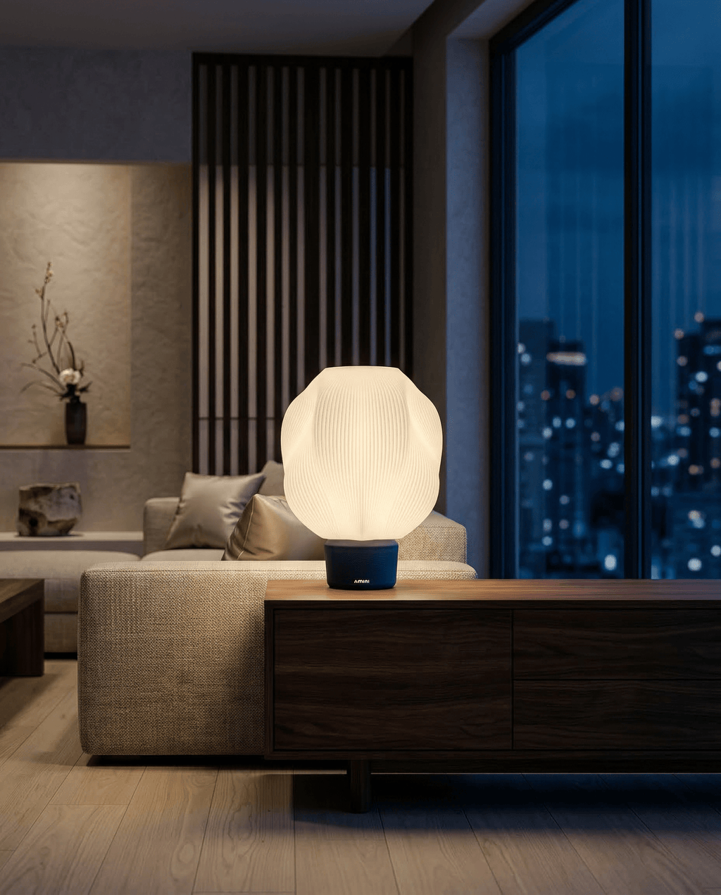 AMINI STRIA Lamp in Navy — lit at night on a dark wood sideboard in a modern apartment with full city skyline view