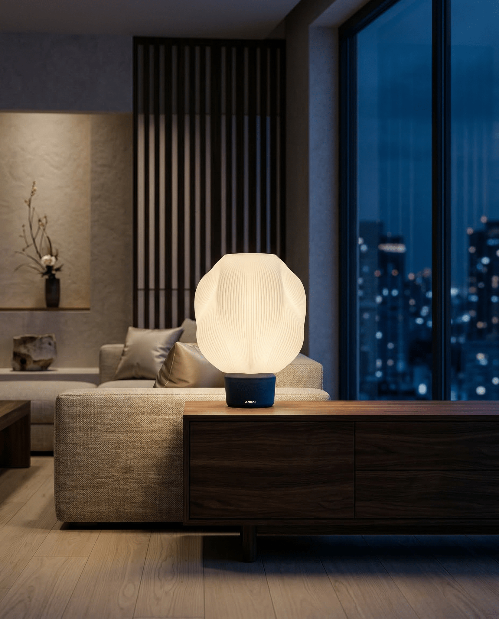 AMINI STRIA Lamp in Navy — lit at night on a dark wood sideboard in a modern apartment with full city skyline view