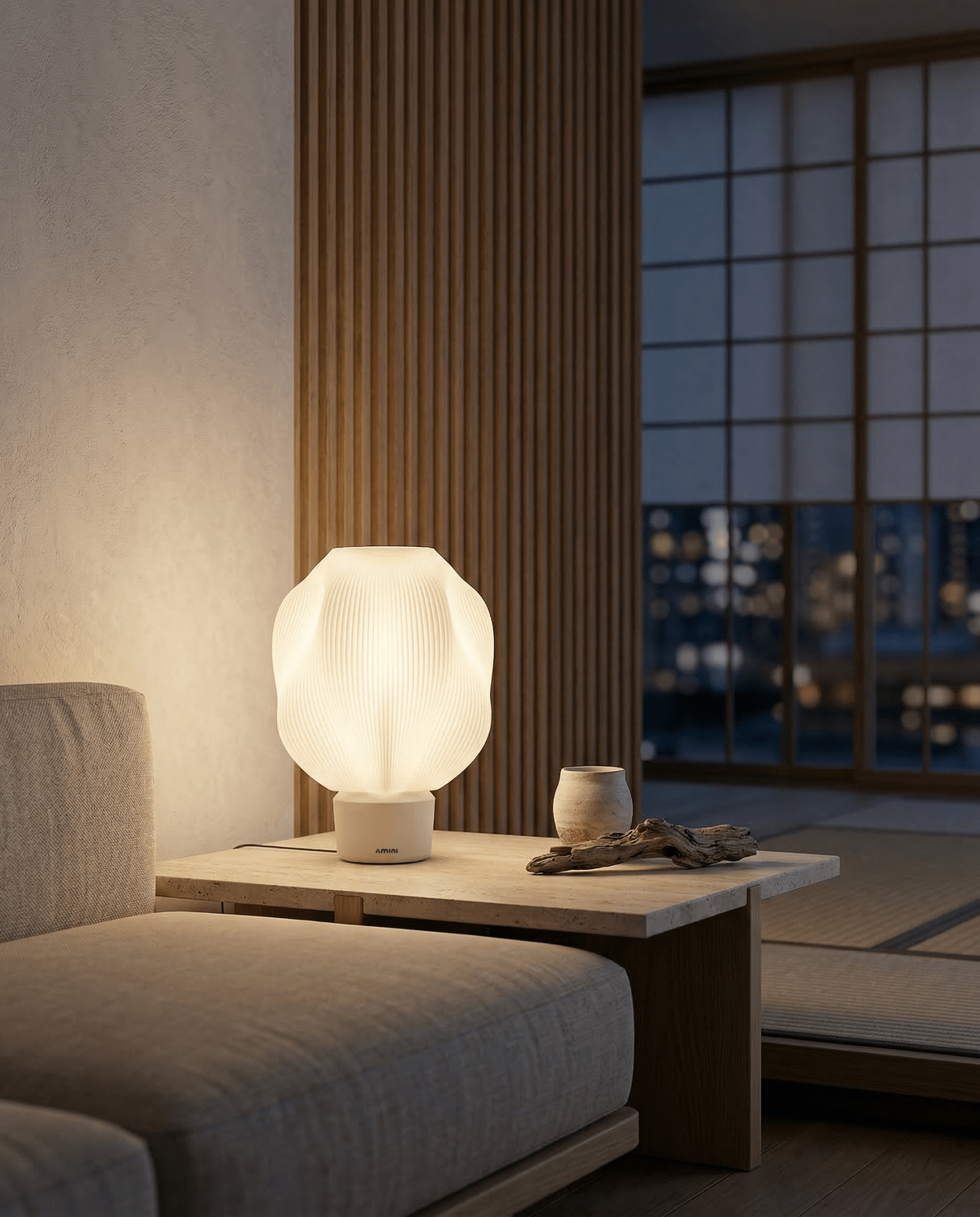 AMINI STRIA Lamp in White — lit at night on a low side table in a Japanese-style room, city lights through window