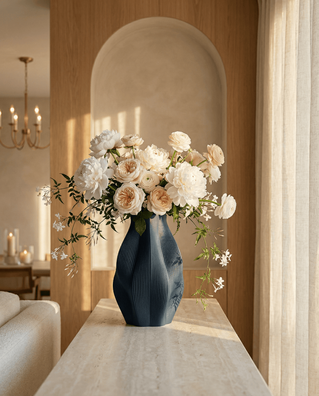 AMINI STRIA Vase in Navy — with white peonies and peach roses on a marble console in an arched niche